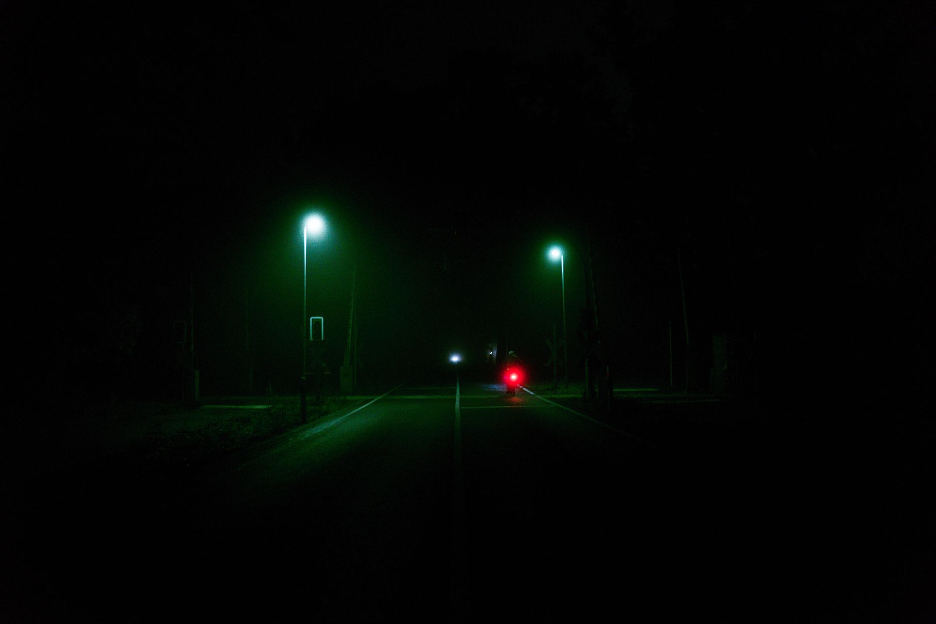 Close-up of a street lamp glowing at night, relevant to debates about reducing street lighting at night in UK communities