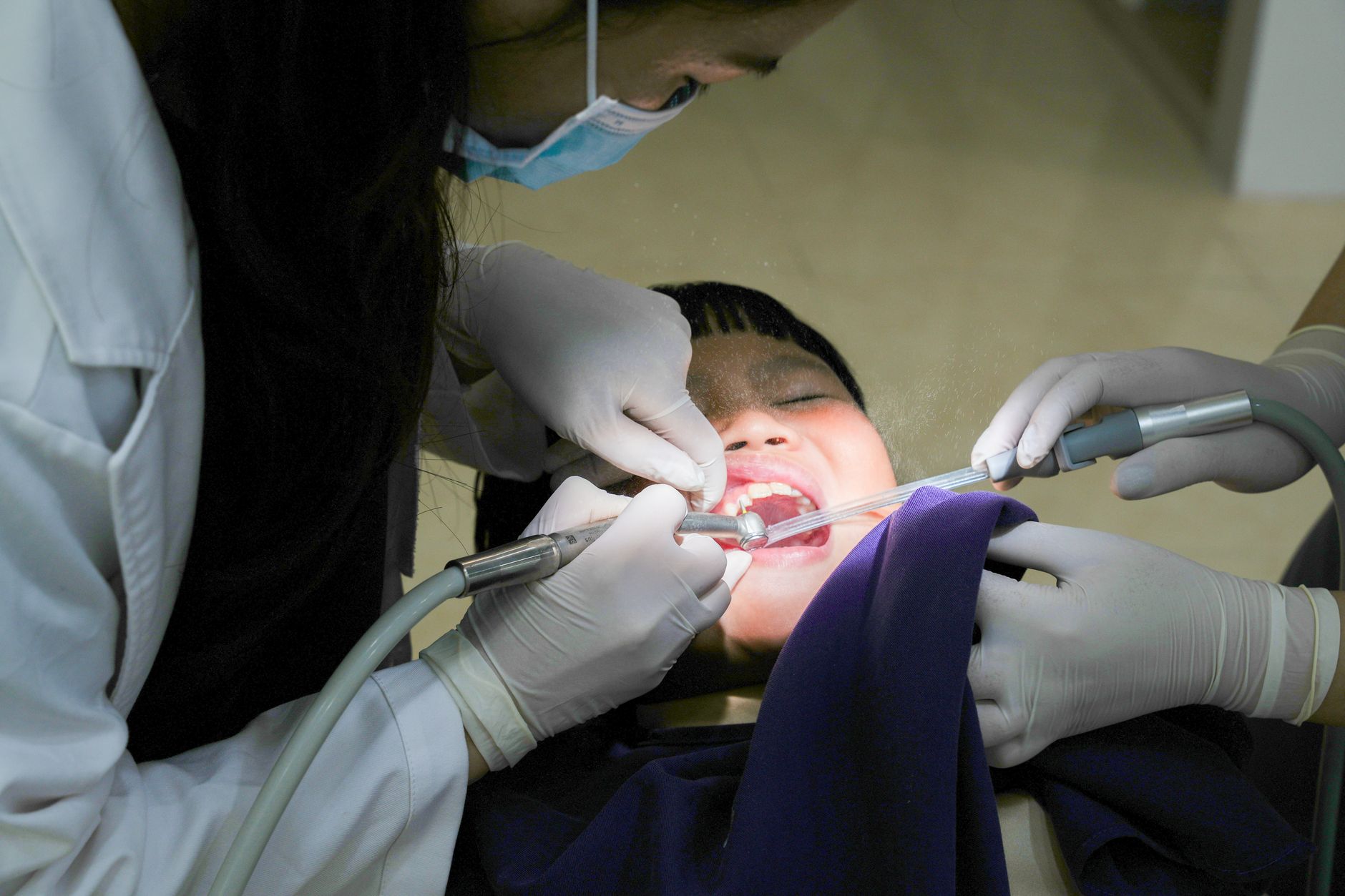 Dentist examining a patient's teeth during an NHS dental appointment